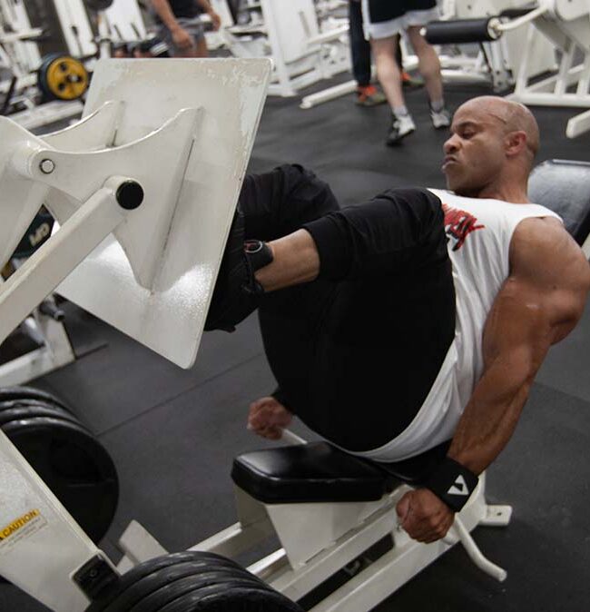 IFBB Pros at Strong and Shapely - Victor Martinez, an IFBB Pro bodybuilder, using a leg press machine at Strong and Shapely Gym.