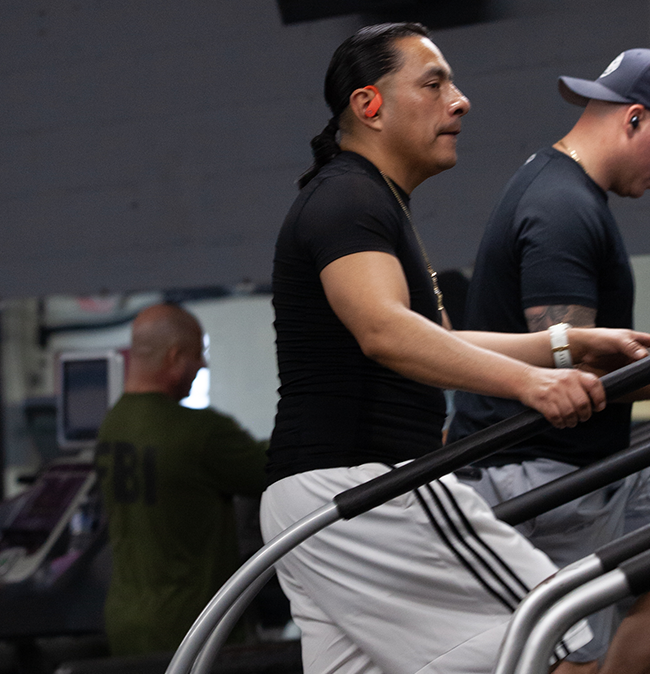 Cardio and Strength Training in NJ - Man in black t-shirt, shorts, and sneakers engaging in a stair climber workout, exemplifying cardio and strength training.